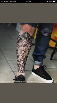 a man's leg with tattoos on it and his foot in the middle of the floor