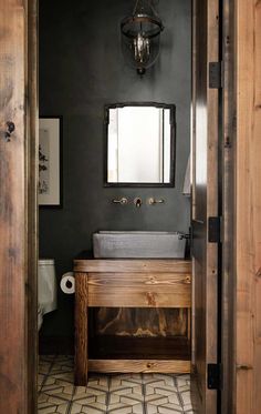 a bathroom with a sink, mirror and toilet paper dispenser in it