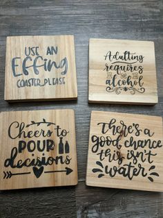 four wooden coasters with hand lettering on them