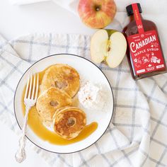 pancakes on a plate with syrup and apple slices next to it, along with cinnamon maple syrup