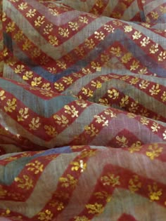 red and gold chevroned fabric with small flowers on the top, as if it were made from silk