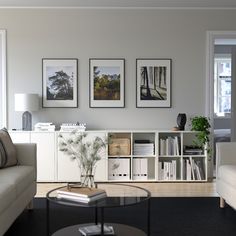 a living room filled with furniture and pictures on the wall