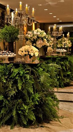 a table topped with lush green plants and cupcakes