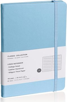 a blue notebook with white writing on the front and bottom pages, sitting next to each other