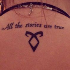 the back of a woman's neck with a tattoo saying all the stories are true