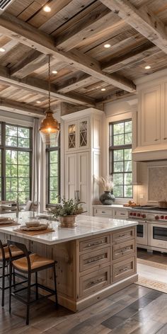 a large kitchen with an island in the middle and lots of windows on both sides