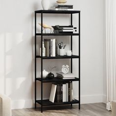 a black shelf with books and other items on it in a room next to a couch