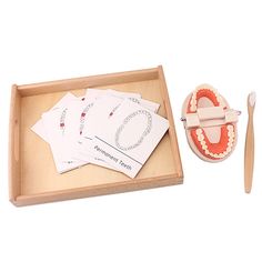 a wooden box with toothbrushes and cards in it