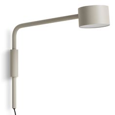 a wall light with a white shade on the side and a black cord attached to it