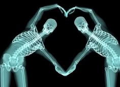 two skeletons making a heart shape with their hands in the shape of a heart, against a black background