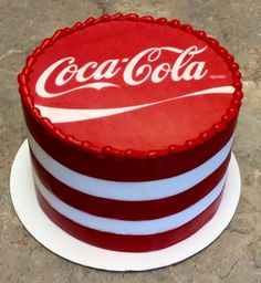 a cake decorated with the logo of coca - cola sits on top of a plate