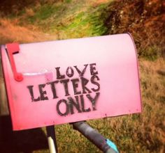 a pink mailbox with the words love letters only written on it in black ink