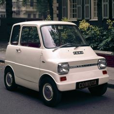 the small car is parked on the side of the road