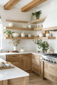 a kitchen filled with lots of wooden shelves and white counter tops next to a stove top oven