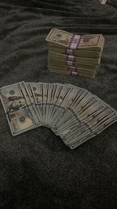 stacks of money sitting on top of a bed