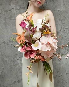 a woman holding a bouquet of flowers in her hands