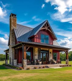 a red house with a metal roof and stone pillars