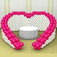 a heart - shaped couch made out of pink and white balloons