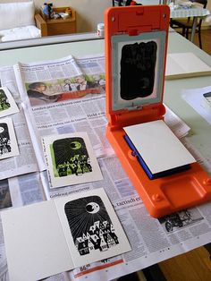 an orange plastic case sitting on top of a table next to papers and other items