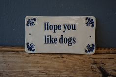 a sign that says, hope you like dogs on the side of a wooden table