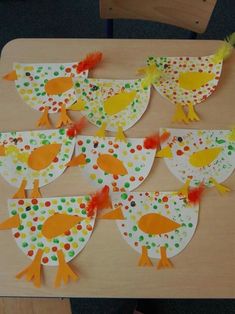 some paper plates with birds on them and dots in the middle, sitting on a table