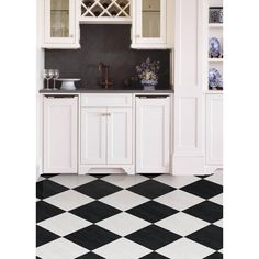 a kitchen with black and white checkered flooring, cabinets and cupboards on the wall