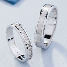 two white gold wedding rings with diamonds on the inside and outside, sitting next to each other