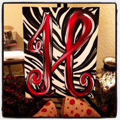 the letter a is painted in red and black on a zebra - print wall hanging