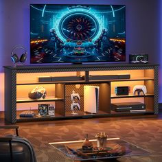 a large flat screen tv sitting on top of a wooden entertainment center in a living room