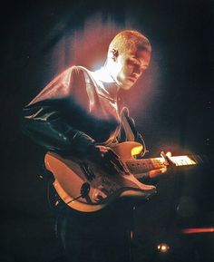 a man playing an electric guitar on stage