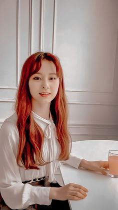 a woman with red hair sitting at a table