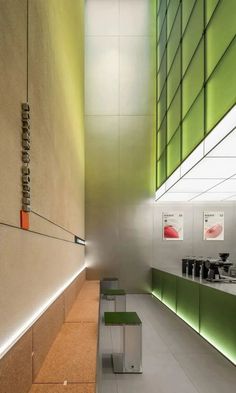 the interior of an office building with green and white accents on the walls, along with benches