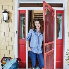 a woman standing in front of a red door