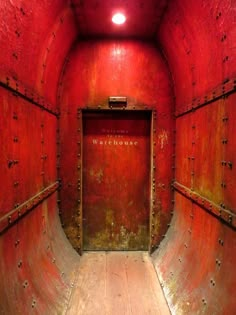 an empty room with red walls and wooden floors