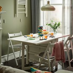 a dining room table with food and drinks on it in front of a large window