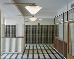 an empty hallway with black and white tiles on the floor