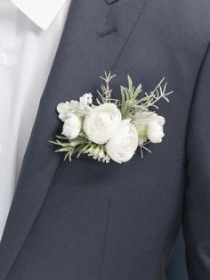 a man in a suit with white flowers on his lapel flower piniont