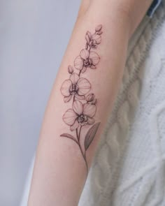 a woman's arm with a flower tattoo on the left side of her arm