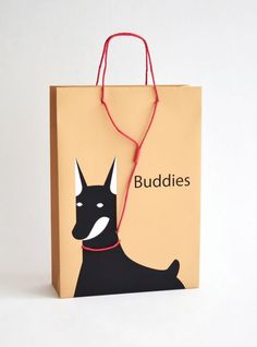 a brown paper bag with a black dog on it's side and the words buddies written in red string