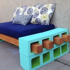 a bench made out of cinder blocks with pillows on top