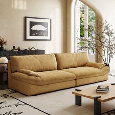 a living room with a couch, coffee table and large open window in it's center