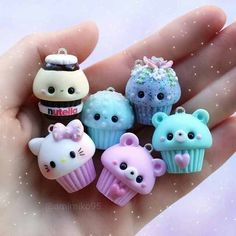 there is a hand that has many small items in it, including cupcakes and cats