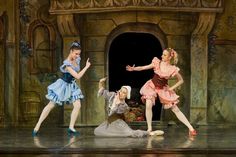 three women in dresses are dancing on stage