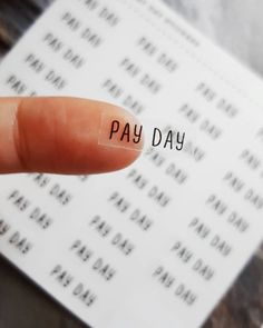 a finger with the word pay day written on it next to a piece of paper