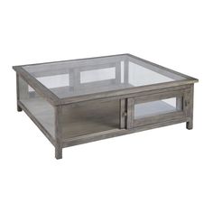 a glass and wood coffee table with two doors on the bottom, in front of a white background