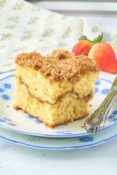 a piece of cake sitting on top of a blue and white plate next to strawberries