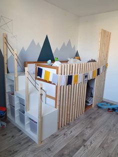 there is a bunk bed made out of wooden slats with mountains on the wall