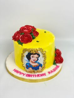 a yellow cake decorated with red roses and a photo on the top that says mulan y'thing year