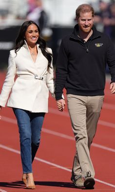 prince harry and his wife are walking on the track