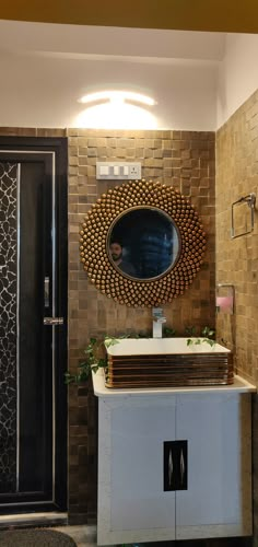 a mirror on the wall above a white cabinet in a room with a black door